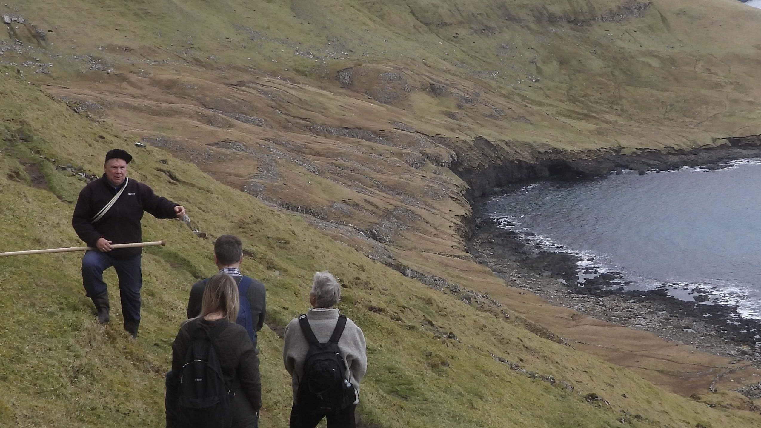 Group of people walking due to the lack of a mountain in the Faroe Islands.